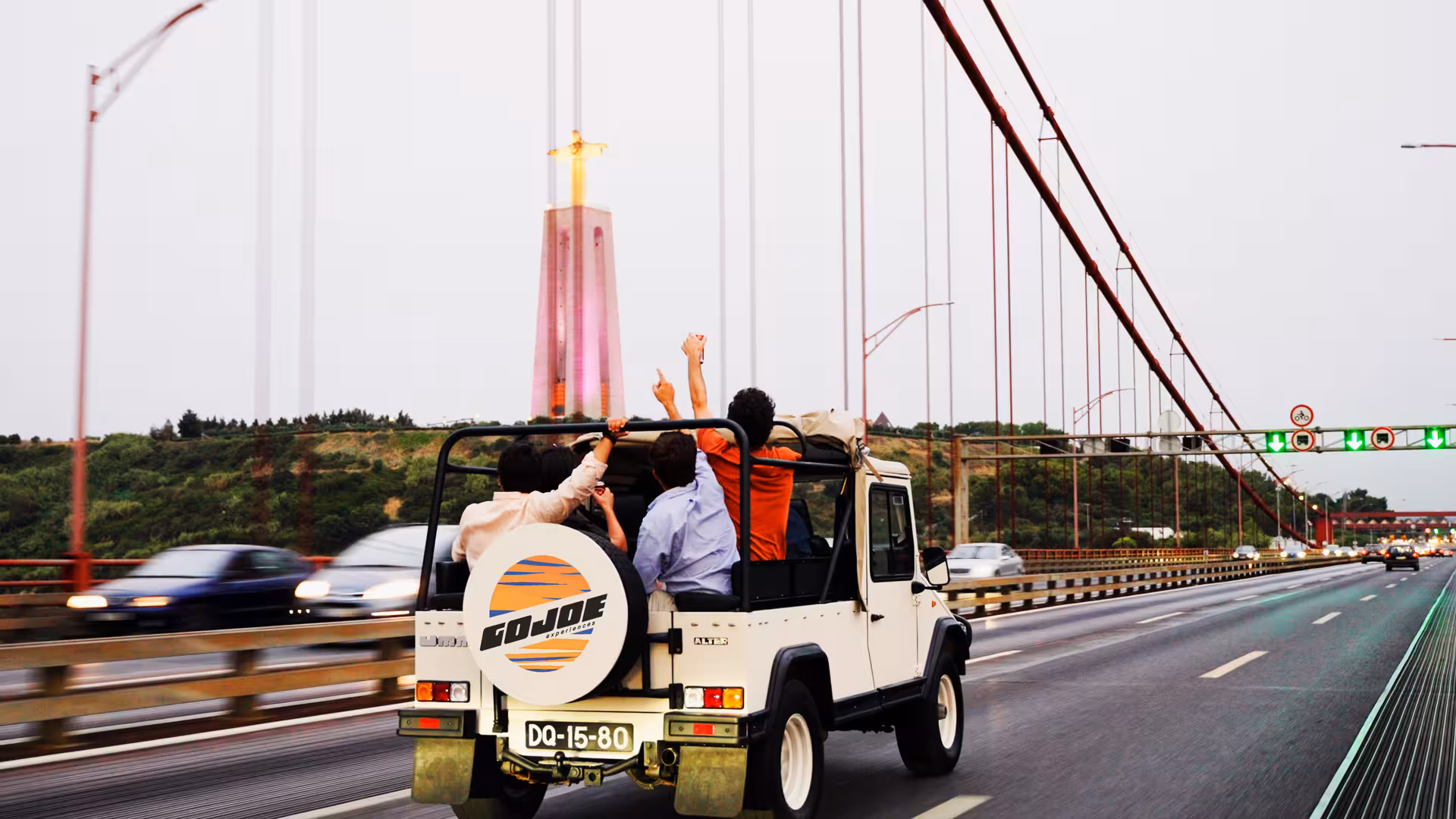 Vintage Jeep Lisbon daily tour crossing 25 de Abril Bridge with views toward Cristo Rei and the Tagus River