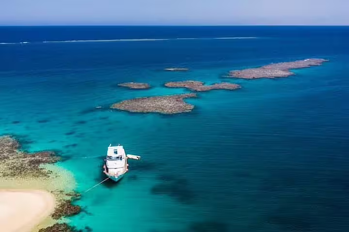 VIP boat anchored in turquoise Red Sea lagoon at Hamata Island, Marsa Alam snorkeling day trip