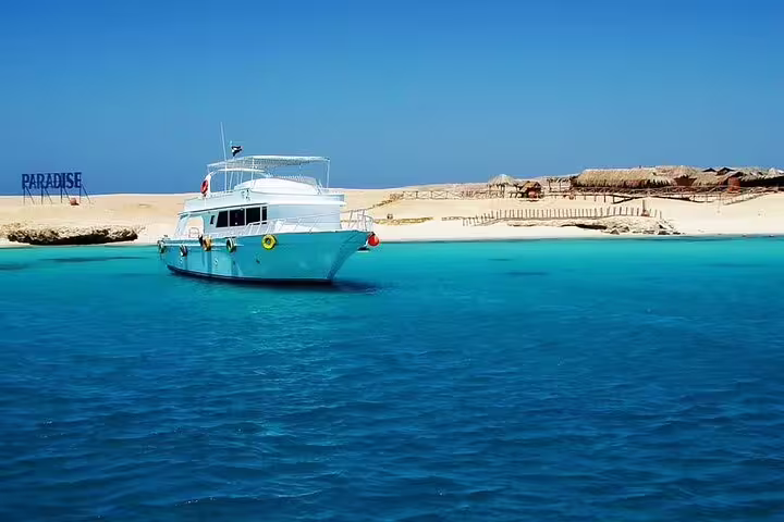 VIP boat anchored in turquoise Red Sea near Hula Hula Island beach, snorkeling day trip excursion from Hurghada