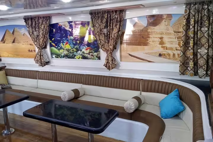 Spacious VIP boat salon for Hurghada Dolphin House snorkeling tour, cushioned seating and tables for comfort