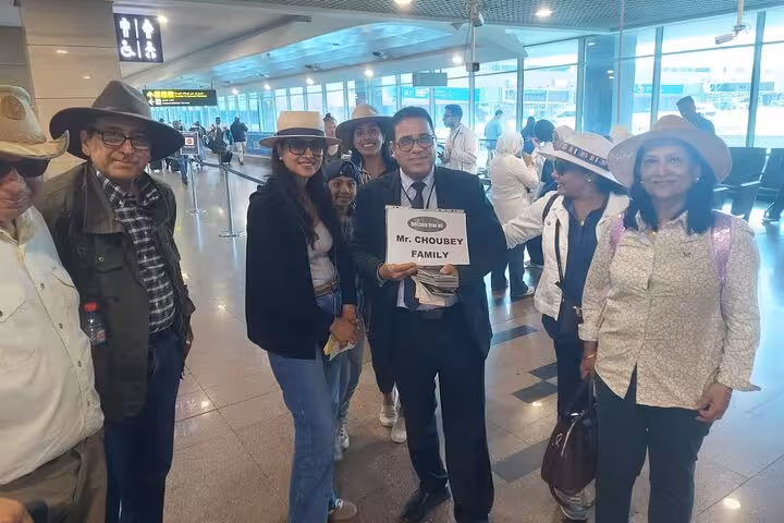 Group of tourists welcomed by a guide holding a sign for VIP Cairo airport meet and assist service.