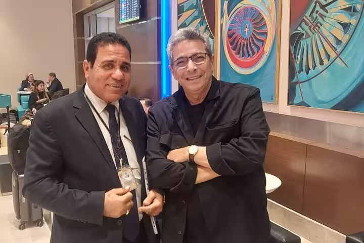 Two men smiling at Cairo airport lounge, showcasing VIP meet and assist services for a seamless travel experience.