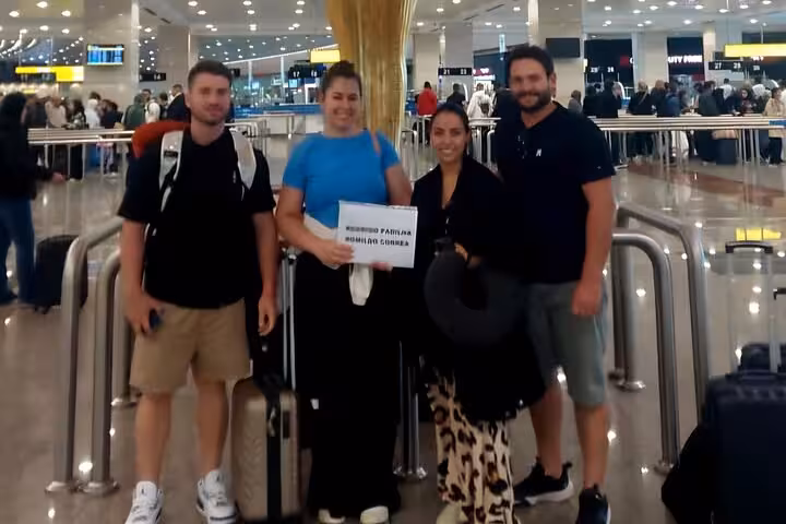 Group of travelers greeted at Cairo Airport with VIP meet and assist service holding personalized welcome sign.