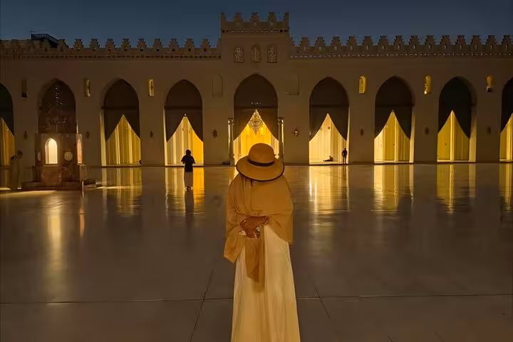 Traveler in illuminated mosque courtyard in Old Cairo, part of VIP Cairo night tour to Al Muizz and bazaar