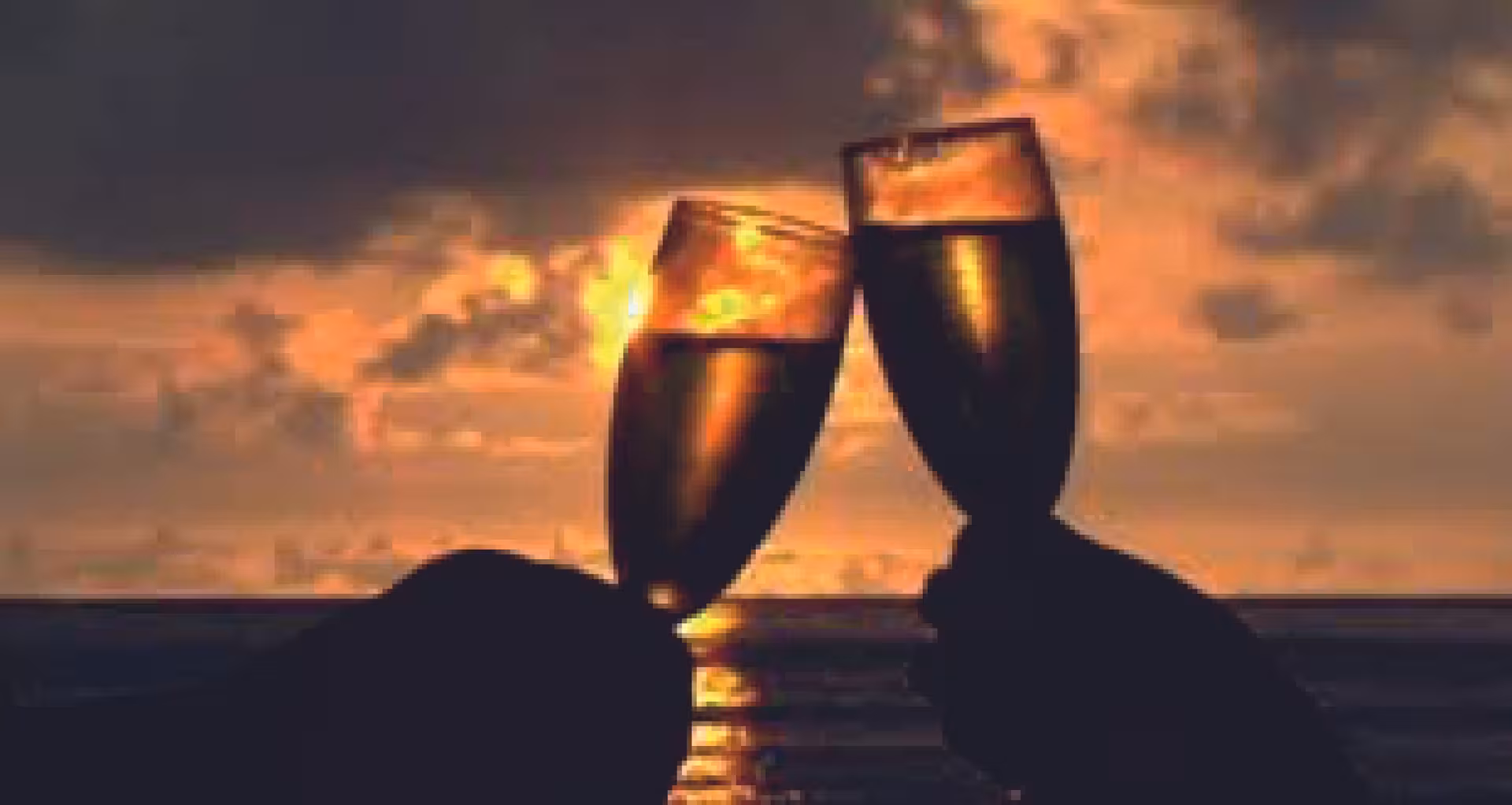 Champagne toast at sunset on a VIP catamaran sail and dine cruise, ocean horizon glowing in golden light