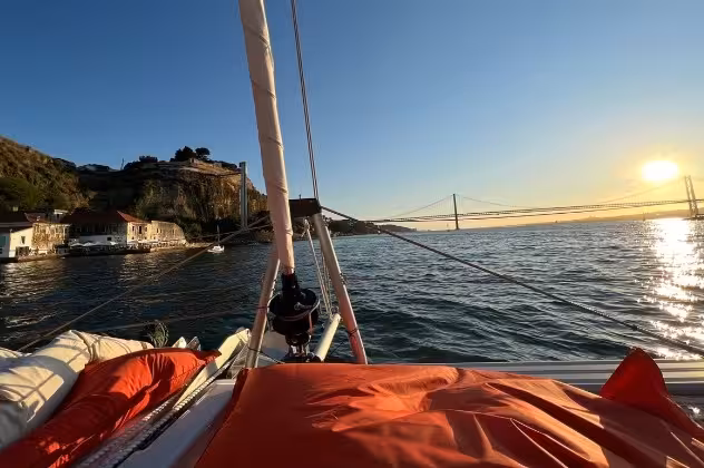 VIP private catamaran sunset tour with cozy deck loungers and river views near the bridge, wine sailing