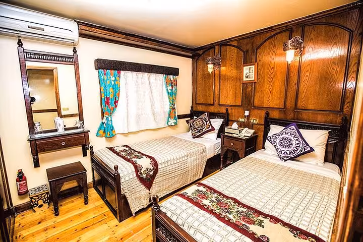 Twin-bed cabin on VIP Dahabiya Nile cruise Luxor to Aswan 4 nights featuring wood interior and AC comfort