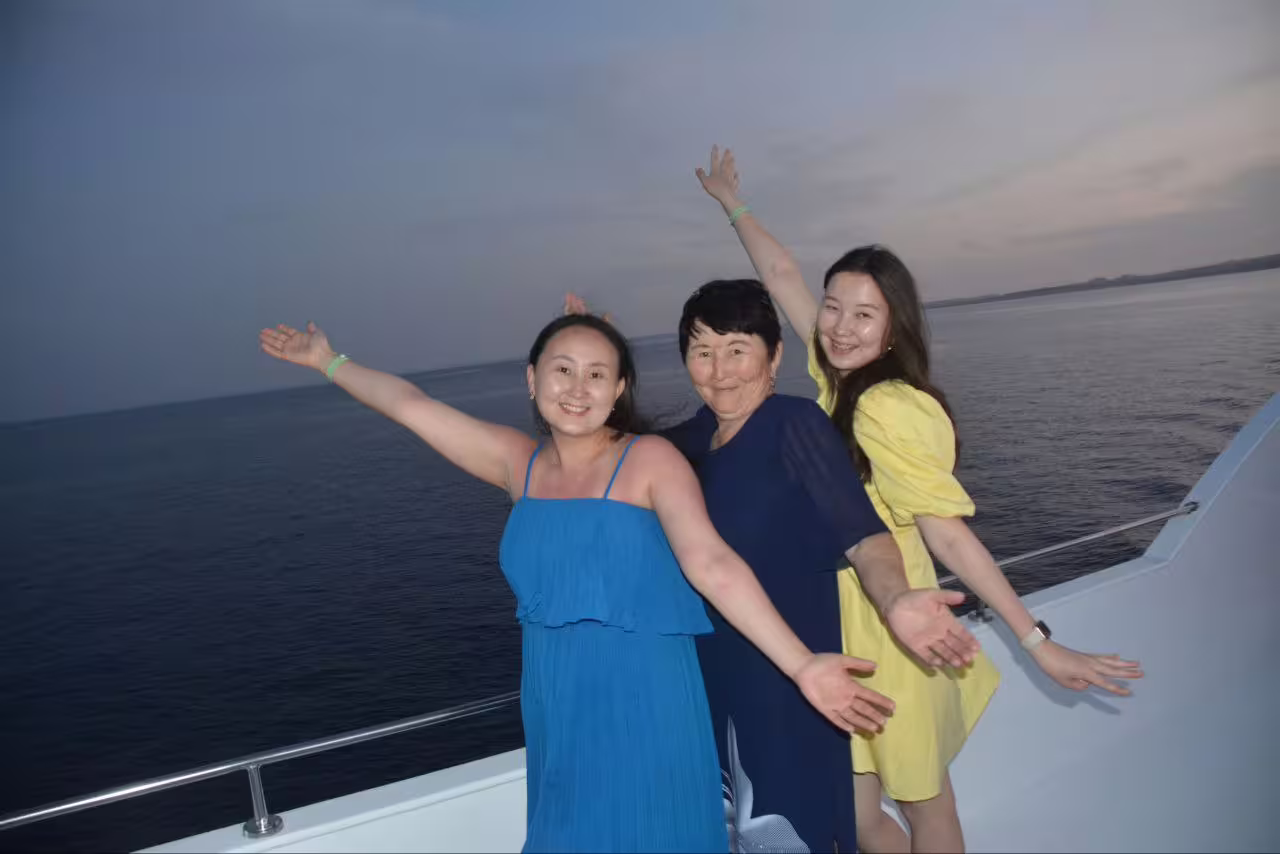 Friends posing on a VIP boat at sunset in Sharm El Sheikh, enjoying a Red Sea dinner cruise experience