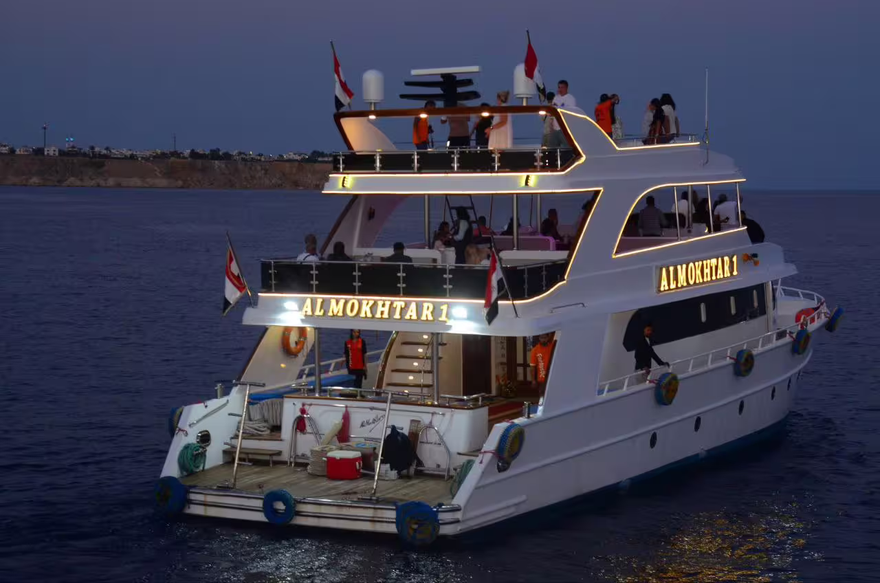 VIP dinner cruise yacht in Sharm El Sheikh sailing the Red Sea at twilight, multi-deck boat with guests