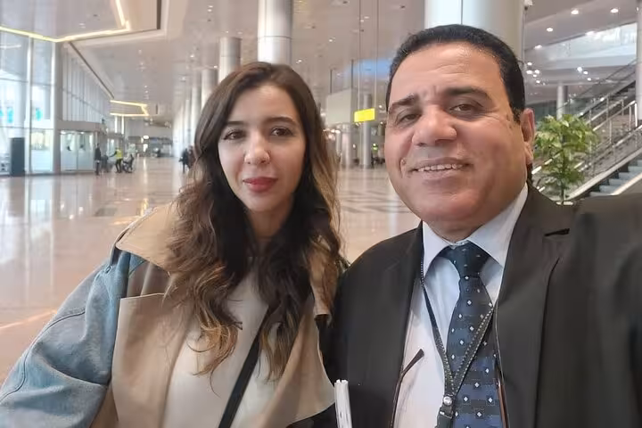 A smiling VIP meet and assist guide with a traveler at Cairo International Airport.