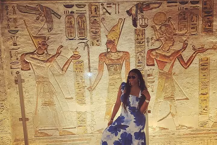 Traveler posing by ancient Egyptian wall reliefs on VIP private 4-day Nile cruise from Aswan, temple tour stop