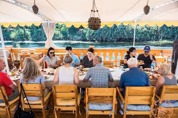 Guests enjoy lunch on a Nile cruise sundeck near Aswan, part of VIP 4 days 3 nights private tour to Luxor