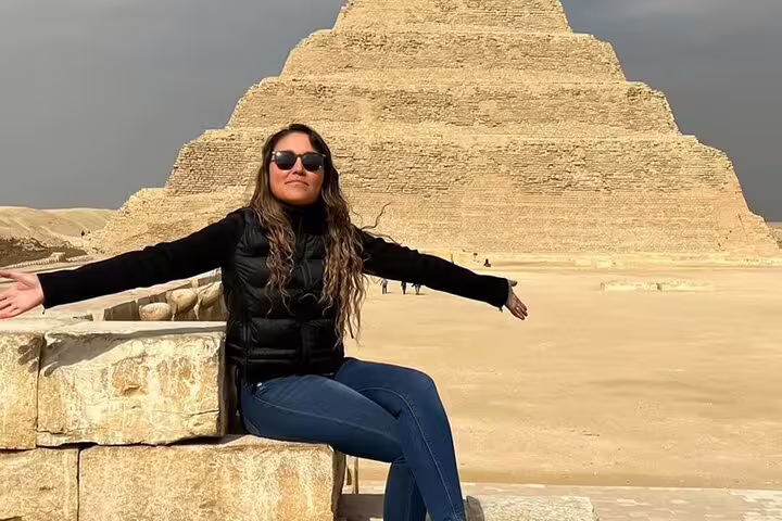 Visitor sitting near the Step Pyramid of Djoser in Saqqara, Egypt, on a guided Memphis and Sakkara excursion