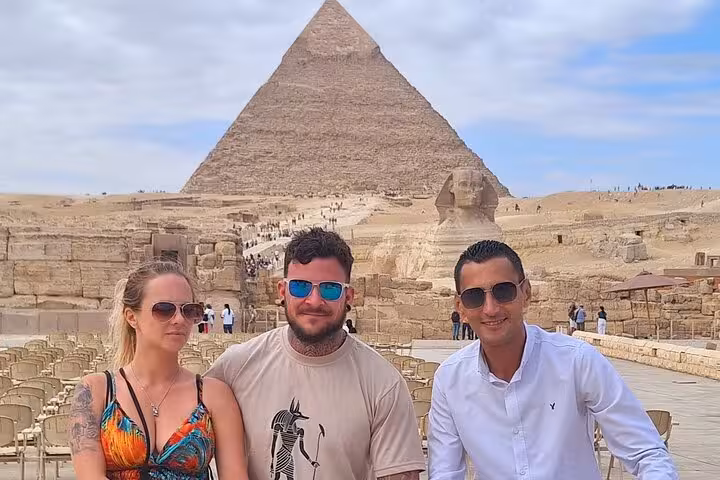 Three visitors pose with the Sphinx and Great Pyramid of Giza in the background, enjoying a highlights tour of Cairo.