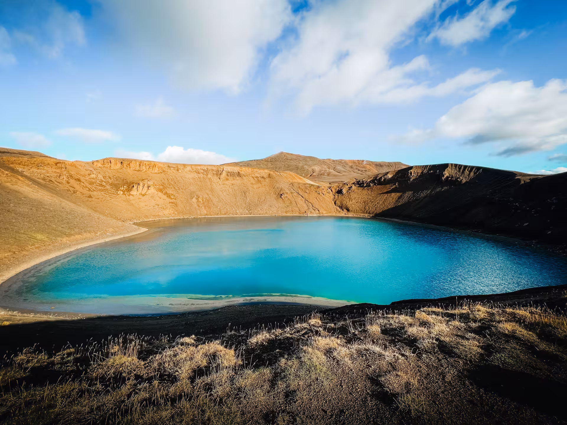 Turquoise Víti crater lake at Krafla volcano on Iceland Diamond Circle tour, geothermal landscape under blue sky