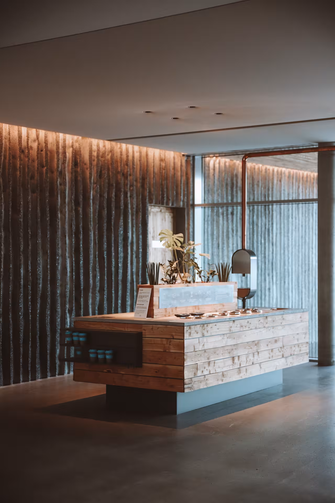 Wooden reception desk with plants at Vok Baths geothermal spa in East Iceland