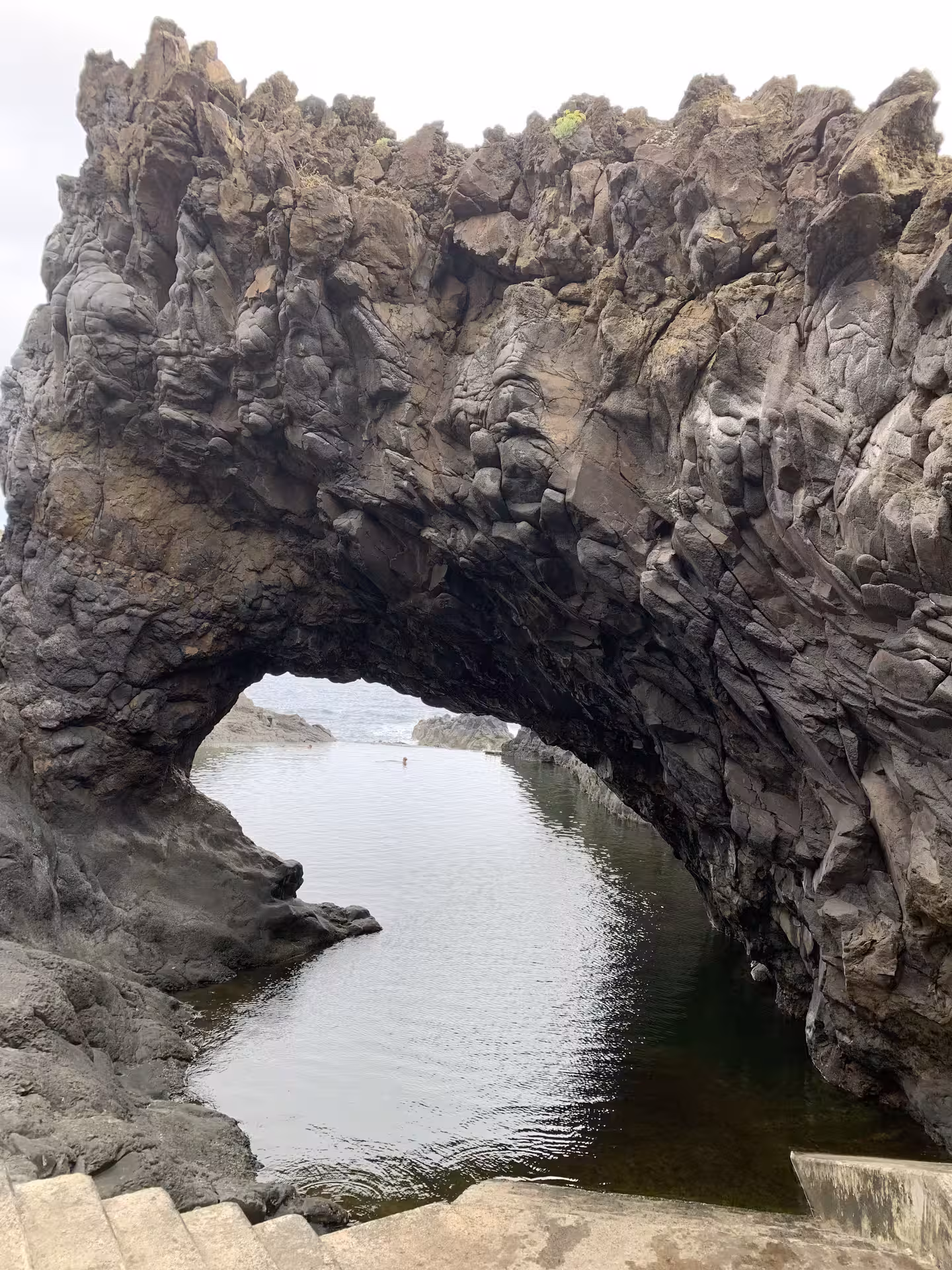 Natural volcanic rock arch framing a serene tidal pool on an exclusive private guided tour for two in Madeira