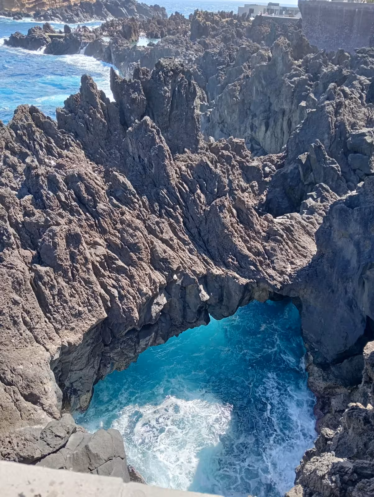 Dramatic volcanic lava rock formation with vivid turquoise ocean pool on an exclusive private guided small group tour.