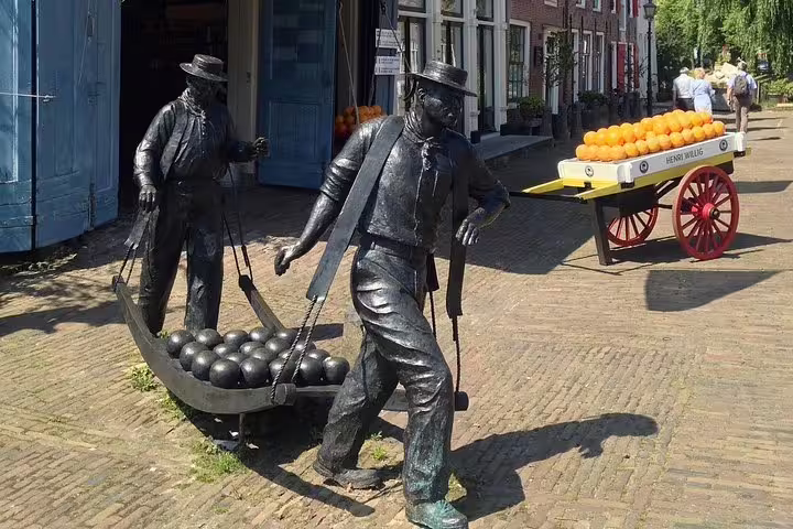 Volendam harbor street statues and cheese cart scene on a half-day Edam and Volendam private tour from Amsterdam