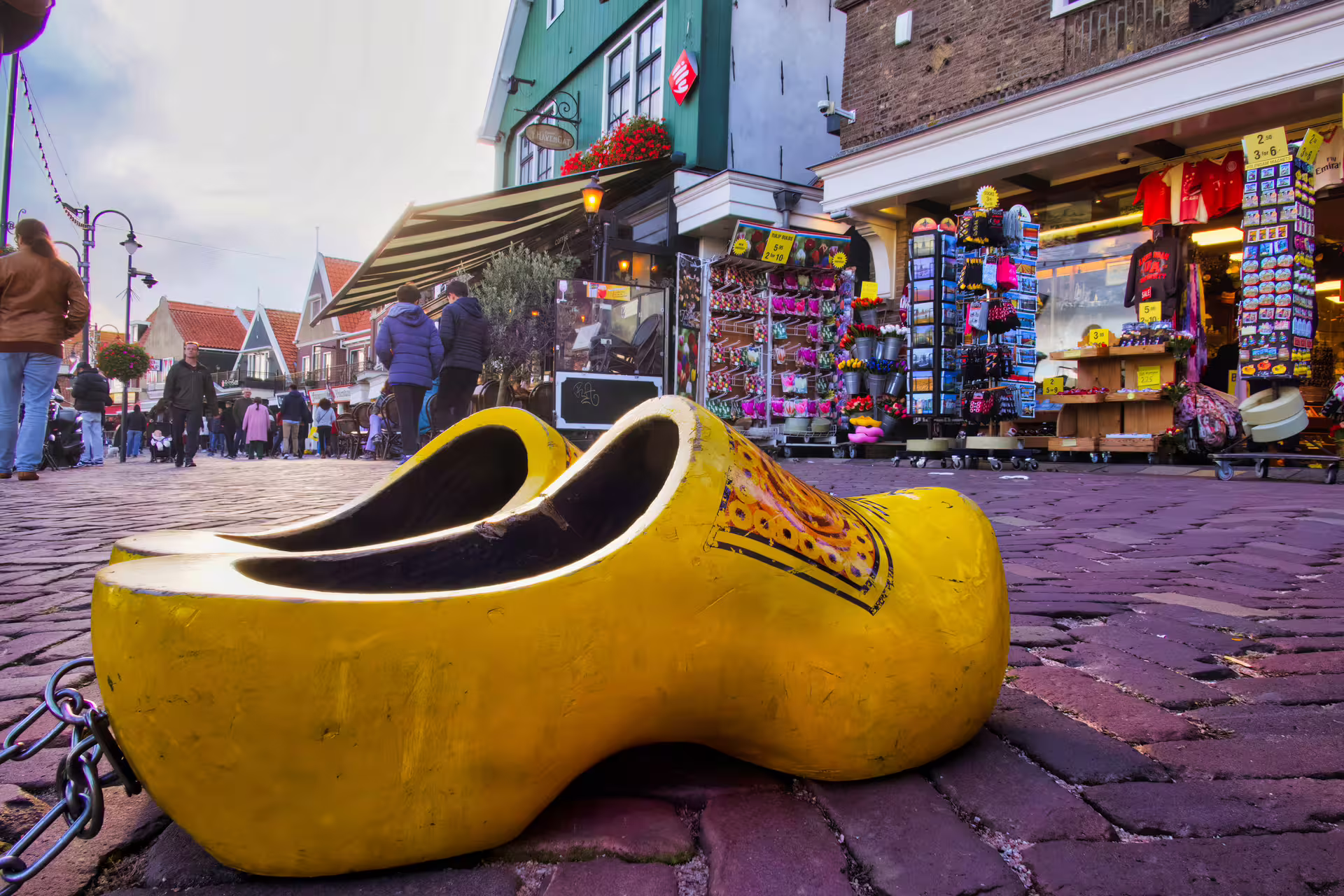 Giant yellow Dutch clog on Volendam shopping street, key stop on 1-day walking tour with multilingual audioguide