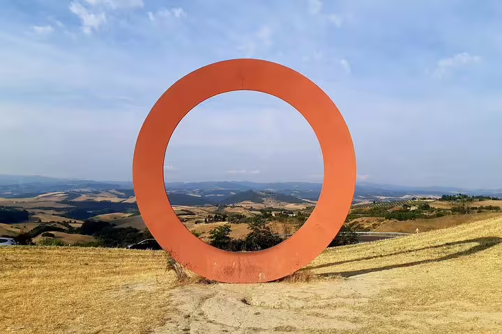 Contemporary red sculpture framing panoramic Tuscan hills near Volterra on a PRIVATE TOUR with lunch and wine tasting