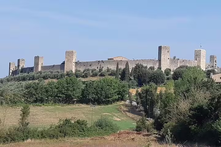 Hilltop medieval walls and towers of Monteriggioni surrounded by Tuscan countryside on a private Volterra and San Gimignano excursion