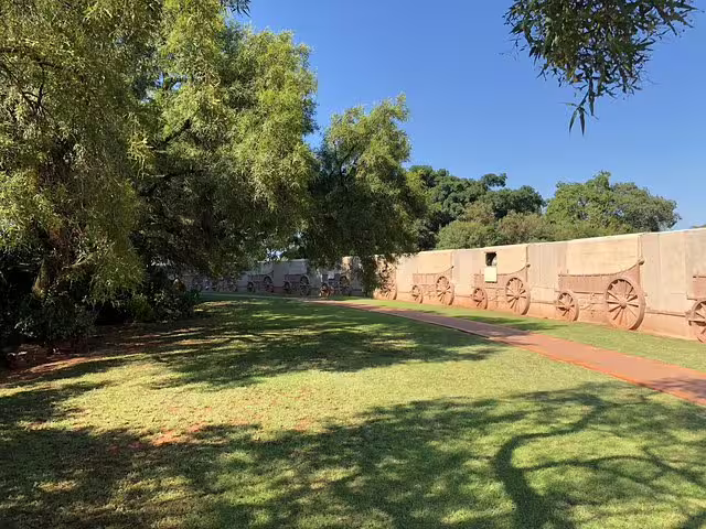 Scenic outdoor view of the Voortrekker Monument's wagon wall and lush greenery, part of Pretoria's historical attractions.