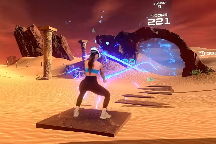Guest playing VRoom 60' VR fitness game in a desert arena, slicing neon targets for an immersive workout