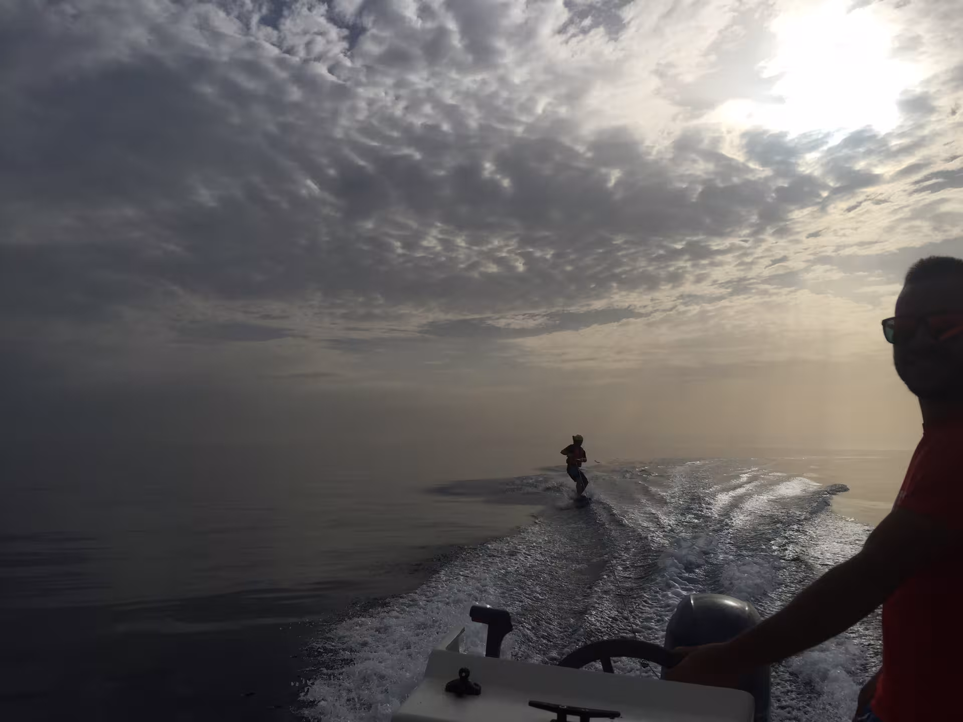 Wakeboarder gliding on calm sea at sunset in Bari Sardo, perfect for adventure enthusiasts seeking thrilling experiences.