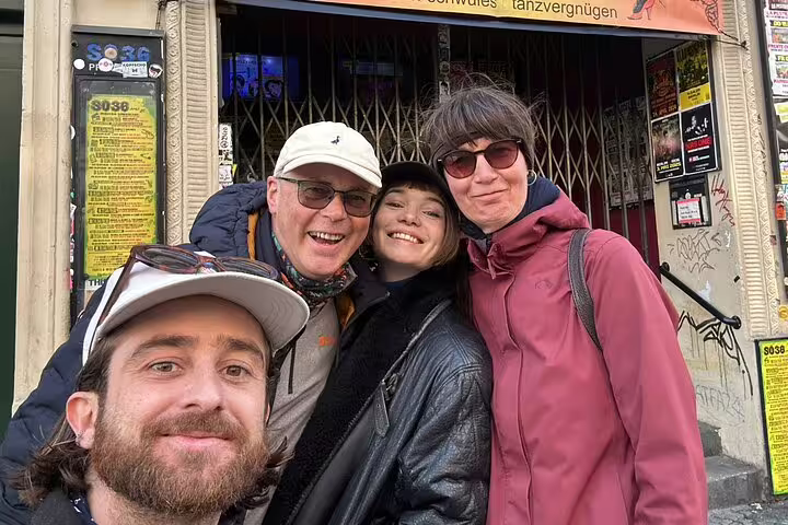 Group of four smiling tourists posing for selfie outside S036 venue in Kreuzberg Berlin
