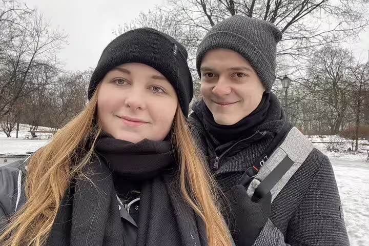 Couple in winter hats and scarves on a snowy walking tour in Warsaw