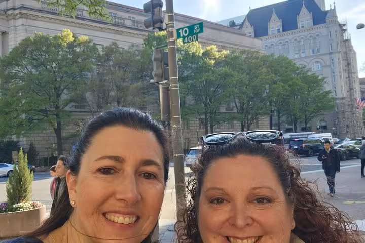 Two women smiling at 10th Street NW in Washington DC with historic buildings in background
