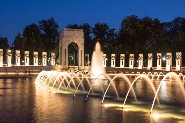 WWII Memorial Pacific Arch with illuminated fountains at night in Washington DC