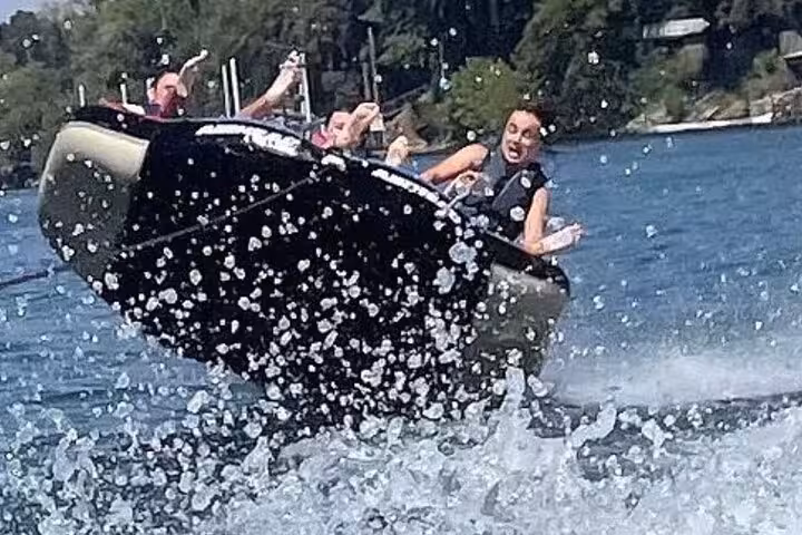 Excited riders on a black inflatable tube pulled by a boat on the French Riviera in Cannes