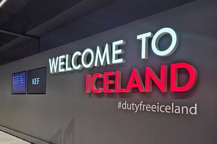 Welcome to Iceland illuminated sign with KEF airport screens at Keflavik International Airport