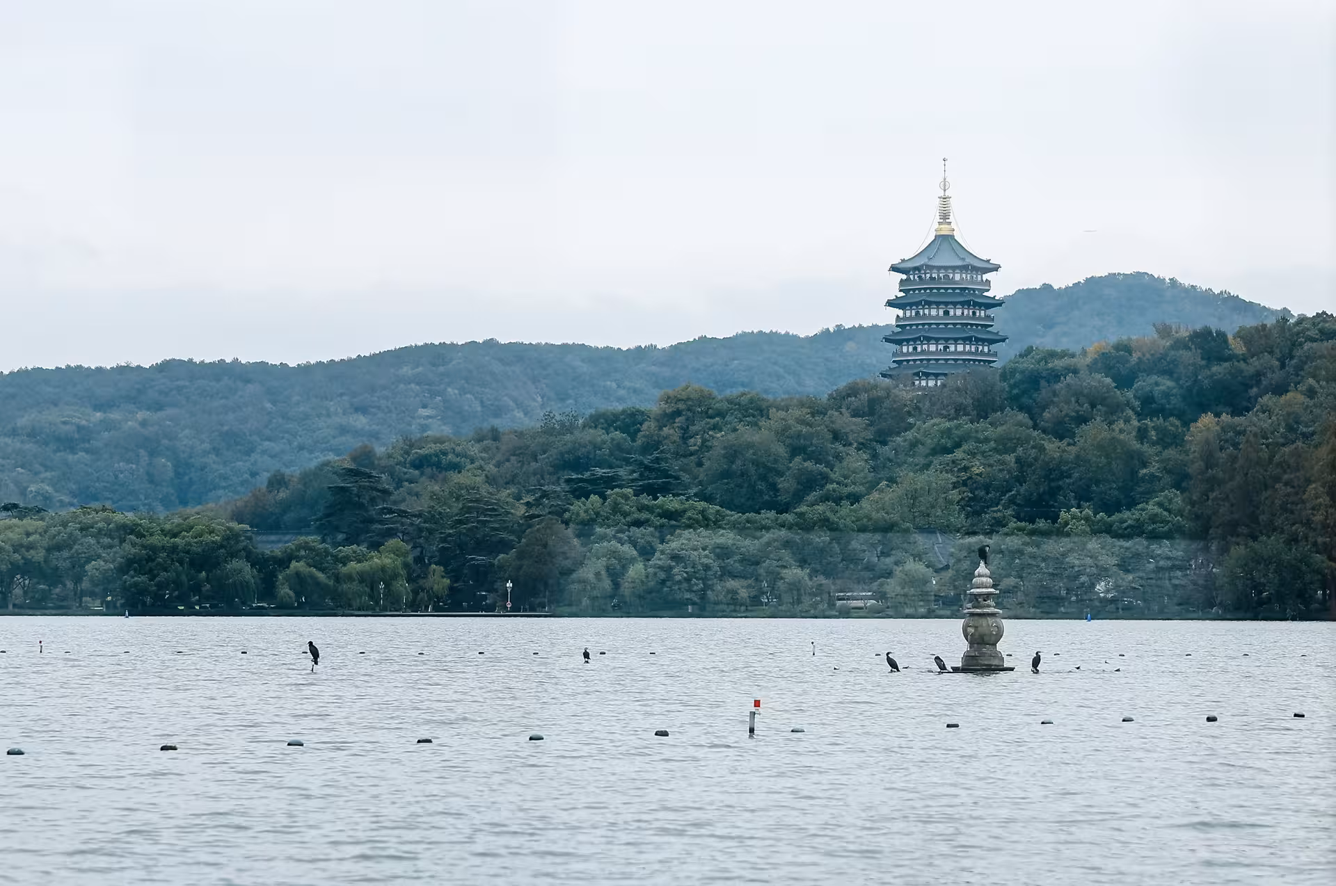 Scenic view of West Lake in Hangzhou featuring a traditional pagoda and lush greenery, perfect for cultural exploration.