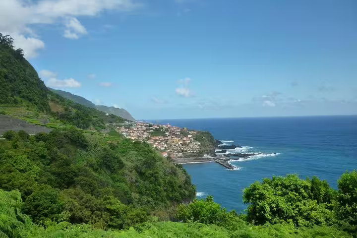 Coastal panorama featuring a charming village perched on cliffs by the vibrant blue ocean on the West Tour.