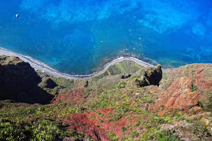 Stunning aerial view of Madeira's coastline with crystal-clear blue waters and rugged cliffs, perfect for scenic exploration.