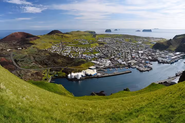 Aerial view of Westman Islands harbor town with volcanic hills and ocean in background, Iceland