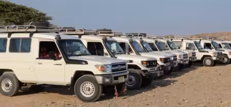 Fleet of white Toyota Land Cruiser 4x4 jeeps parked in desert terrain in Marsa Alam