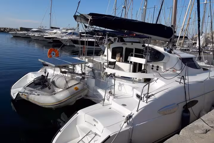 Modern white catamaran moored in Marseille marina, vessel for a full-day private sailing tour with skipper