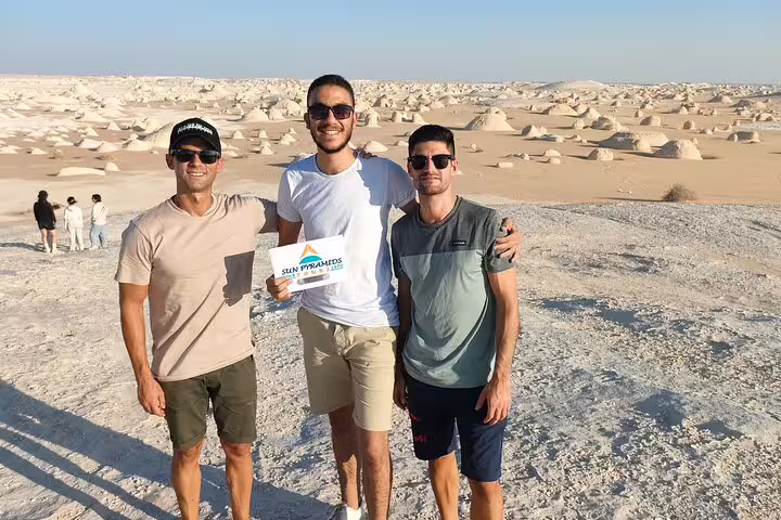 Travelers pose at Egypt’s White Desert chalk formations on a 3 days 2 nights Bahariya tour from Cairo