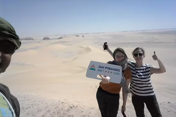 Travelers posing in Sahara sands on private White Desert and Bahariya Oasis day tour from Cairo by 4x4