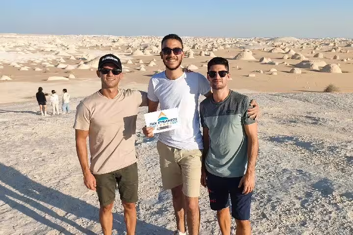 Friends posing at White Desert chalk formations on a private 4-day White Desert and Bahariya Oasis safari