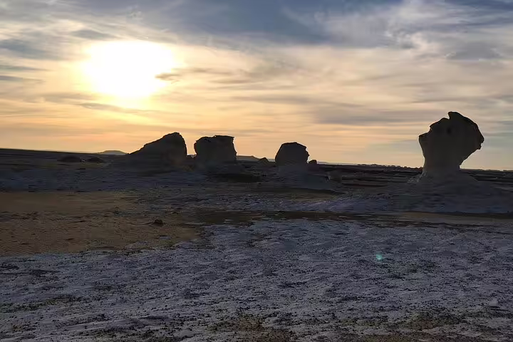 Sunset over White Desert chalk rock formations on a private 2-day Jeep safari from Bahariya Oasis