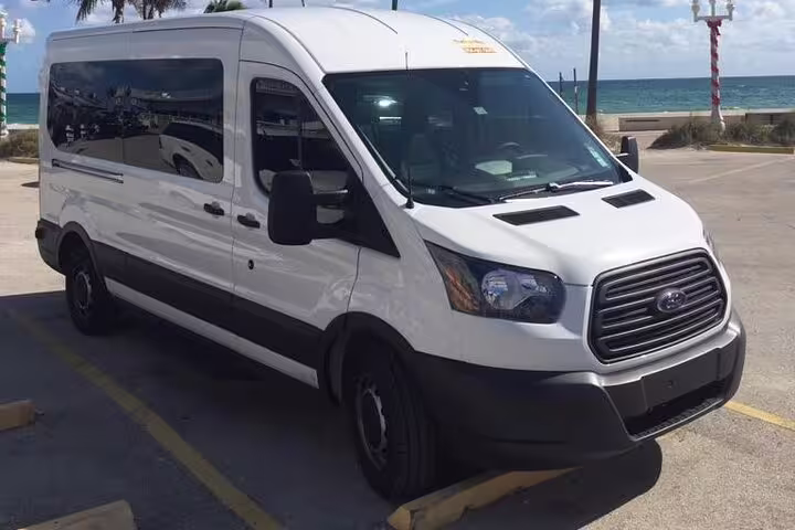 White Ford Transit passenger van parked near Nassau beach for private cruise port transfer