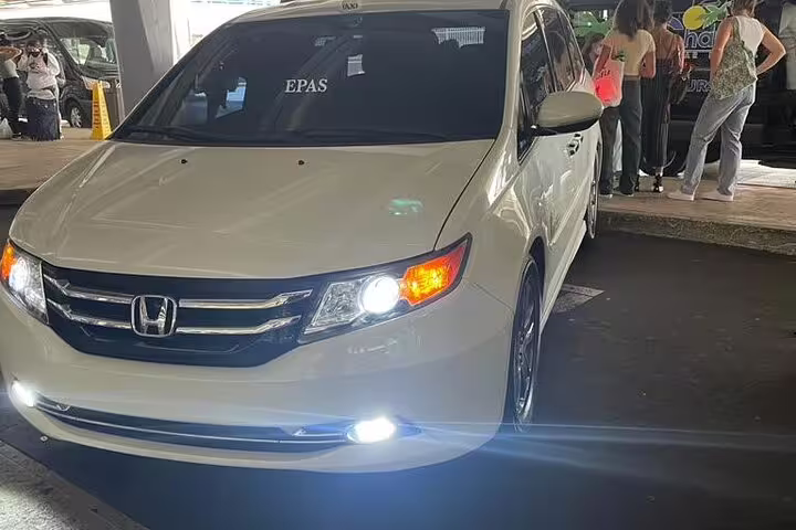 White Honda minivan at Dubai Airport DXB offering private transfer service to your hotel in Dubai