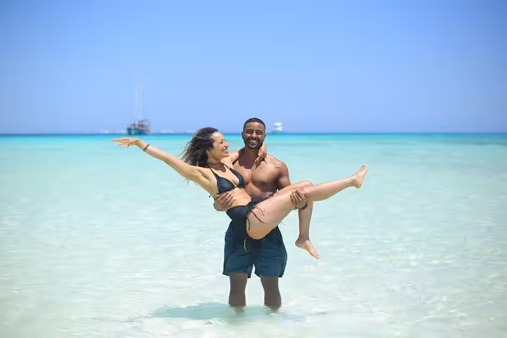 Couple enjoying shallow turquoise lagoon at White Island on Sharm El Sheikh day sail to Ras Mohamed National Park