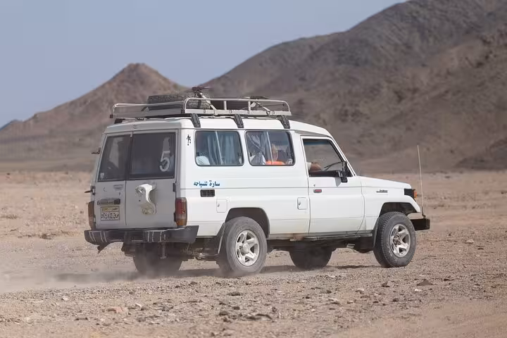 White 4x4 Jeep driving in Hurghada desert mountains on stargazing safari adventure with Bedouin dinner