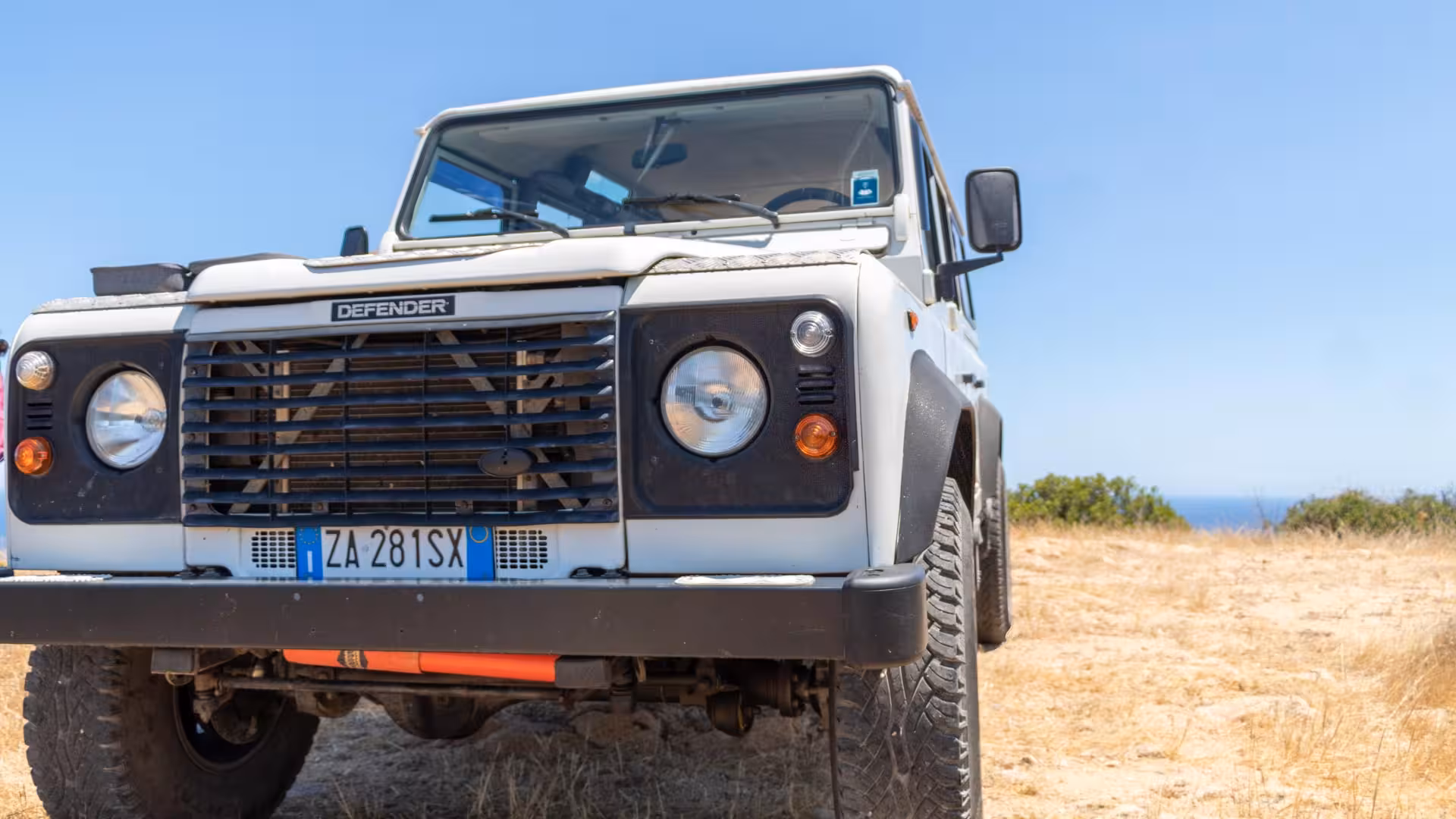 White Jeep parked on a sandy terrain during the Orosei private tour in Biderosa and Capo Comino.